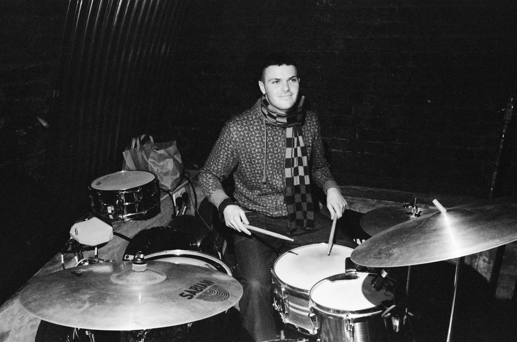 greyscale image of joe playing the drumkit
